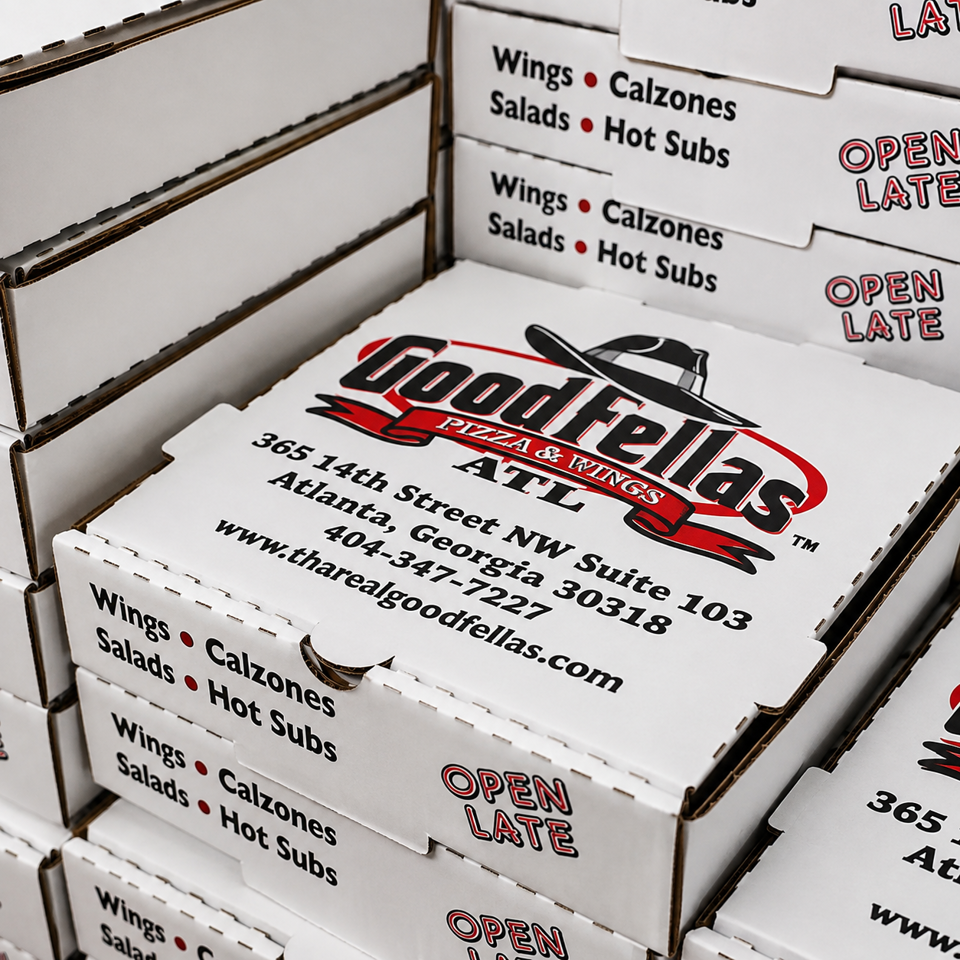 Stacked Goodfellas Pizza & Wings boxes display the Atlanta address, menu items, website, and “Open Late” branding.